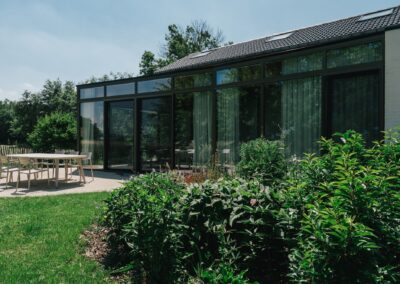 Tuinontwerp met ecologische bloemenborders en verhardingen in gewassen grindbeton